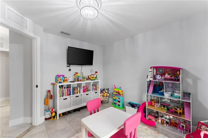 Playroom with tile patterned floors and an inviting chandelier