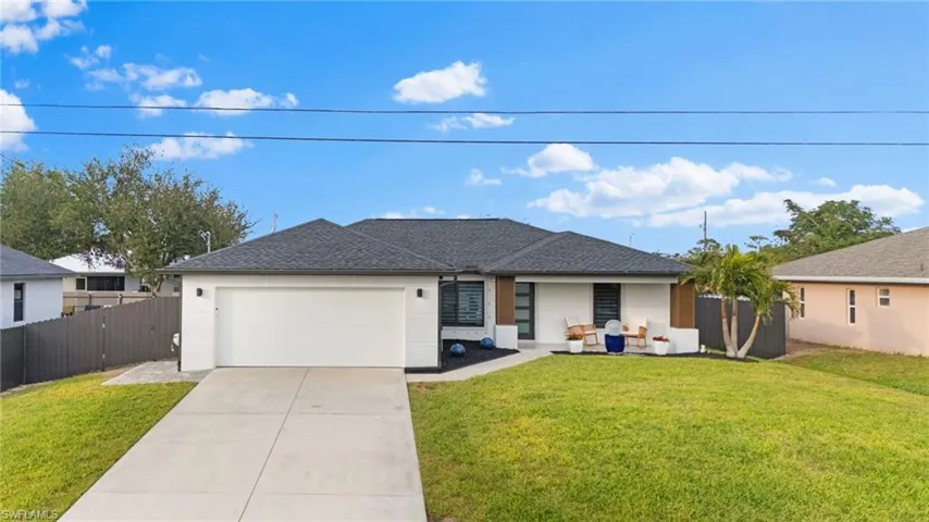 Single story home with a garage and a front lawn