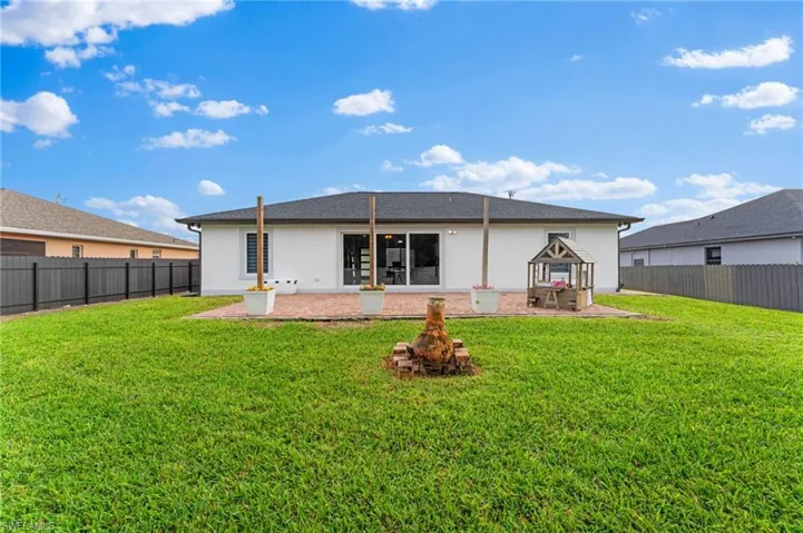 Rear view of house featuring a patio area and a lawn