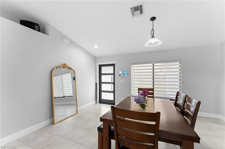 Tiled dining area with lofted ceiling