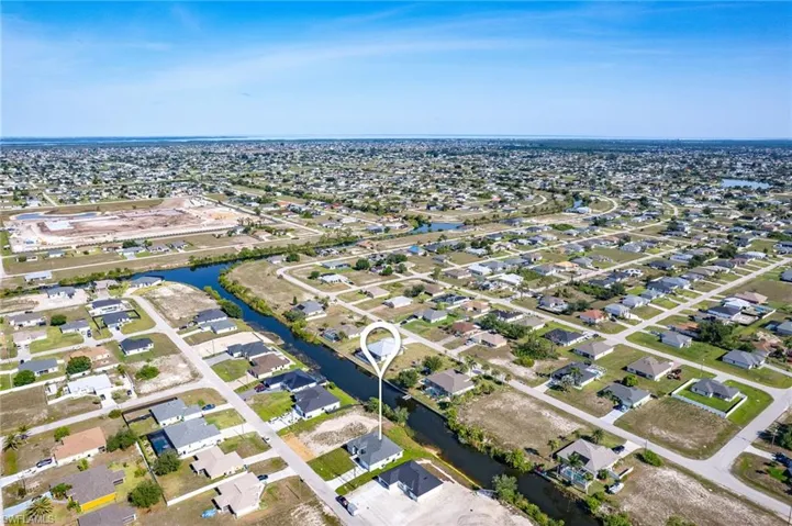 Aerial view of property and surrounding area with nearby suburban area and a nearby body of water