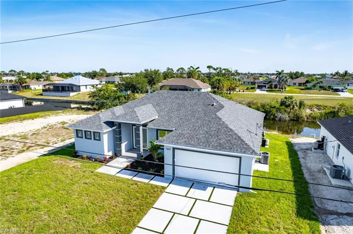 View of front of property featuring a front lawn, a residential view, roof with shingles, and stucco siding