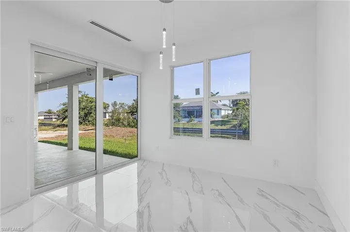 Spare room with marble look tile flooring and baseboards