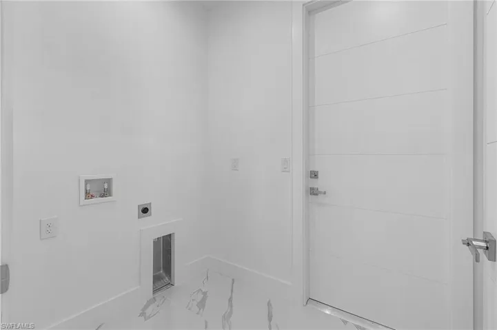 Laundry area featuring light marble finish floors, hookup for a washing machine, and electric dryer hookup