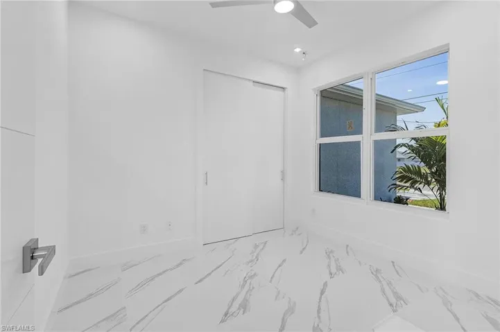 Unfurnished room with marble look tile flooring, ceiling fan, and recessed lighting