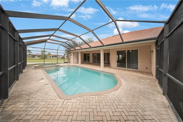 View of pool with a sunroom, a pool with connected hot tub, a patio, and a lanai