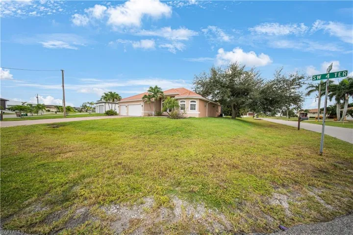View of front facade with driveway, a front yard, and a garage