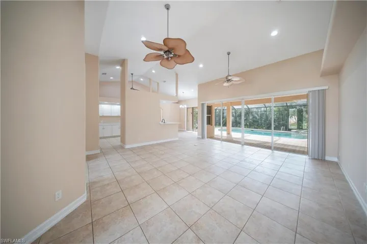 Unfurnished living room featuring light tile patterned flooring, high vaulted ceiling, a ceiling fan, and recessed lighting