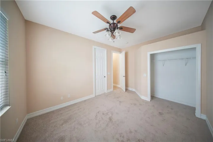 Unfurnished bedroom with carpet floors, a ceiling fan, and a closet