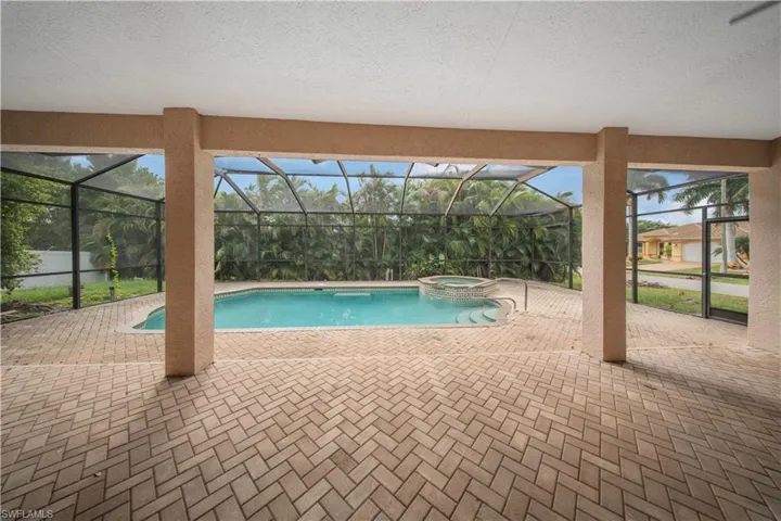 View of swimming pool with a patio, glass enclosure, a sunroom, and a pool with connected hot tub