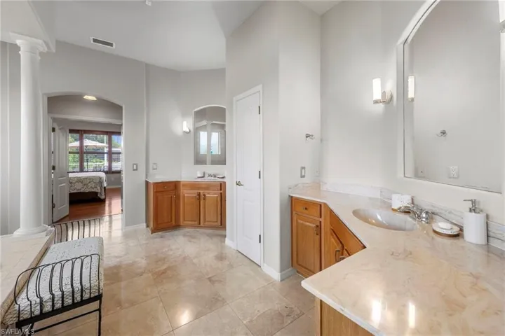 Ensuite bathroom featuring decorative columns and two vanities