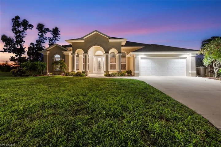 Mediterranean / spanish house featuring driveway, stucco siding, a lawn, and a garage