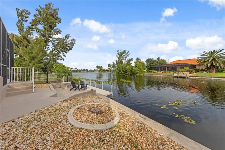 Dock area featuring a water view, a patio, and a lanai