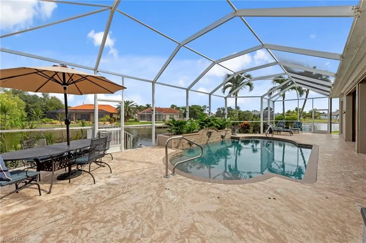 Outdoor pool featuring a sunroom, a patio area, a lanai, and a water view