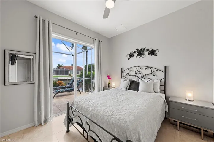 Bedroom with light tile patterned floors, access to outside, and ceiling fan