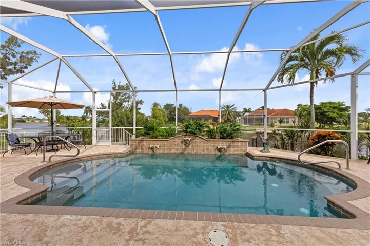 Outdoor pool featuring a sunroom, a patio, and glass enclosure