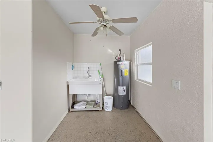 Utility room featuring water heater and a sink