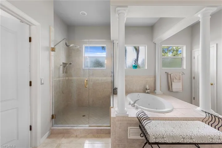 Bathroom featuring a stall shower, a jetted tub, and tile patterned flooring