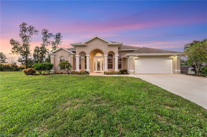 Mediterranean / spanish home featuring stucco siding, concrete driveway, a front yard, and a garage