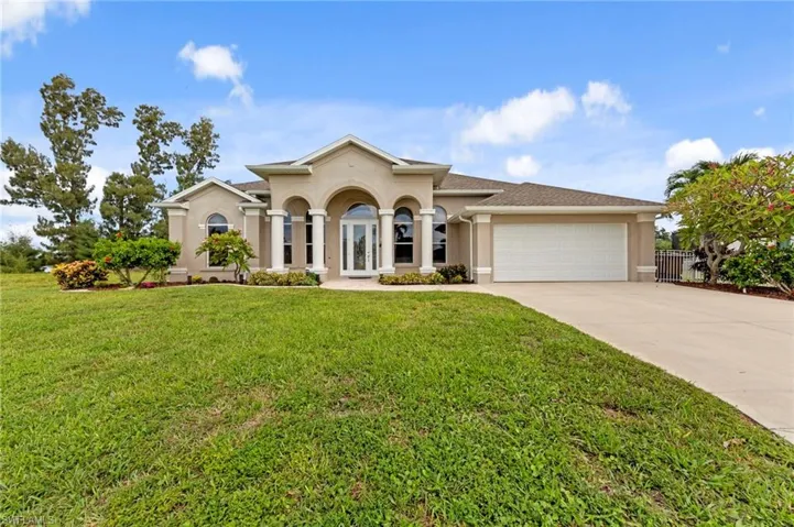 Mediterranean / spanish home with stucco siding, concrete driveway, a front yard, and a garage