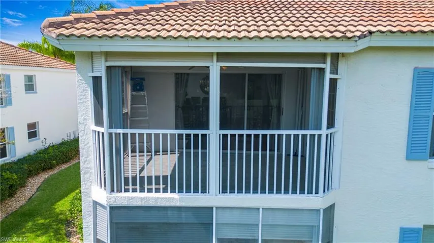 View of side of property with a tiled roof, a sunroom, and stucco siding