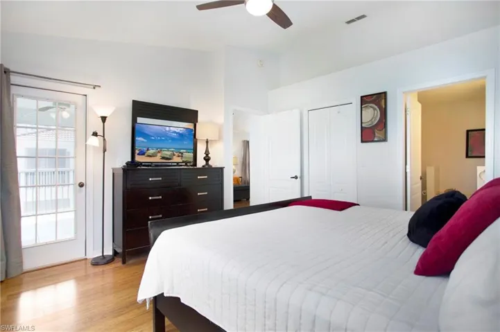 Bedroom featuring light wood-style flooring, access to outside, a ceiling fan, and vaulted ceiling