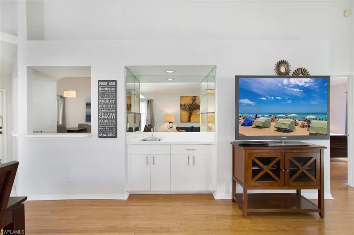 Bar with white cabinets, light wood-type flooring, and light countertops