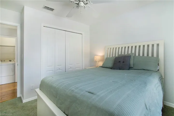 Bedroom with washer / clothes dryer, carpet floors, a closet, and a ceiling fan