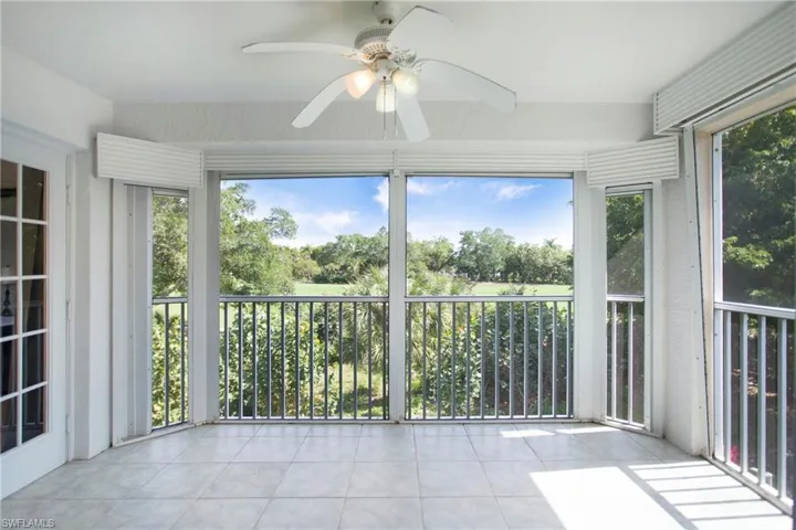Unfurnished sunroom with a ceiling fan and tile patterned floors