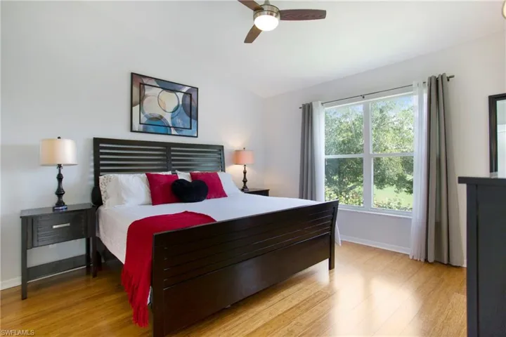 Bedroom with vaulted ceiling, light wood-type flooring, and ceiling fan