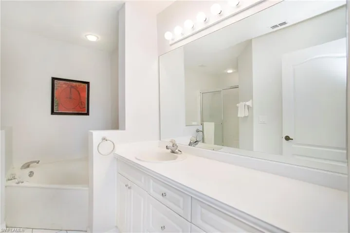 Full bath with vanity, a garden tub, a stall shower, and light tile patterned floors