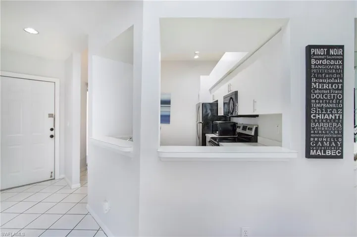 Kitchen with appliances with stainless steel finishes, light countertops, light tile patterned floors, a peninsula, and recessed lighting