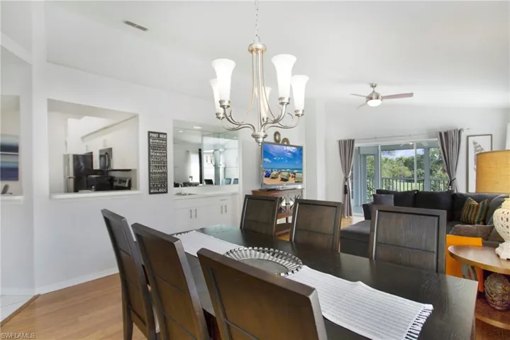 Dining area featuring light wood-style floors, a chandelier, and a ceiling fan