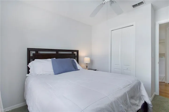 Carpeted bedroom with a closet and a ceiling fan