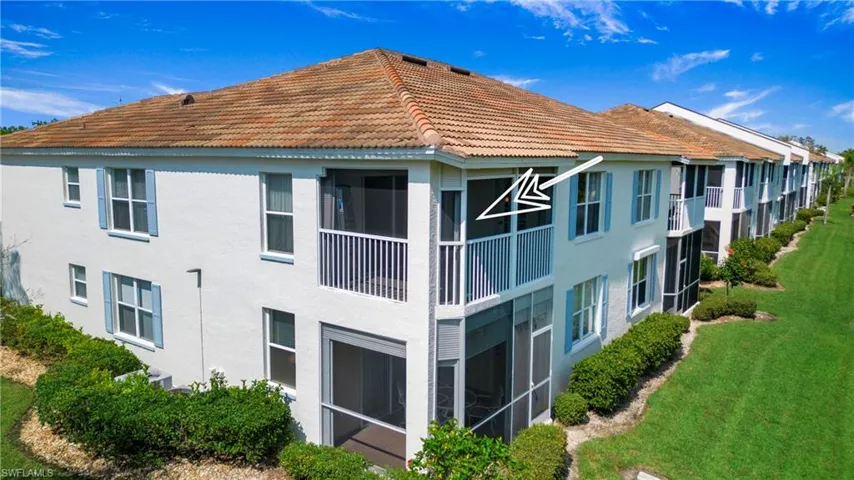 Rear view of house with a sunroom, stucco siding, a balcony, and a tiled roof