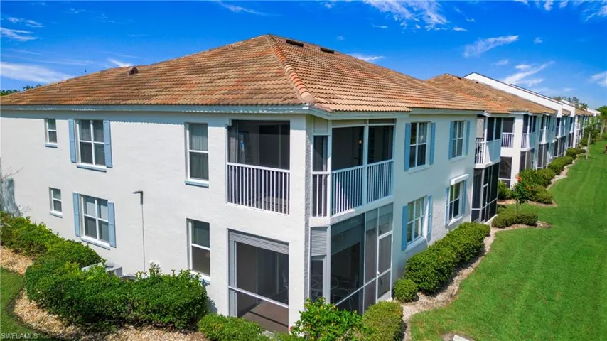 Back of property featuring a sunroom, a balcony, and stucco siding
