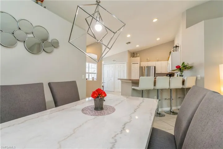 Tiled dining space featuring high vaulted ceiling