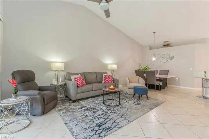 Tiled living room with high vaulted ceiling and ceiling fan