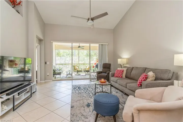 Tiled living room with high vaulted ceiling and ceiling fan