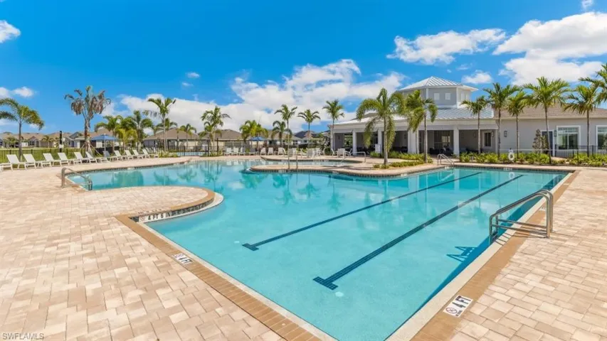 The property features a large outdoor swimming pool with lane markers, surrounded by a paved deck with lounge chairs