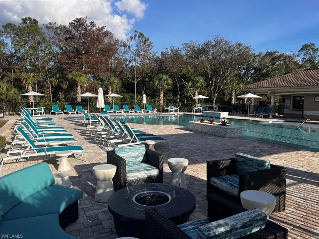 View of swimming pool featuring a patio area and an outdoor living space with a fire pit