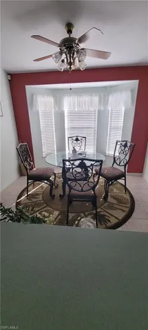 Dining area featuring a ceiling fan and baseboards