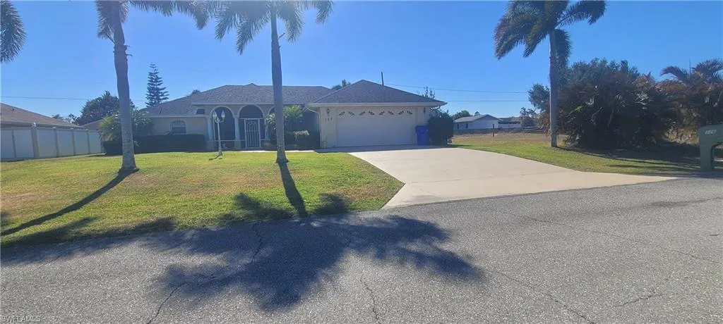 Ranch-style house with driveway, an attached garage, and stucco siding