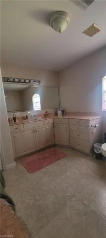 Laundry room featuring a textured ceiling and light tile patterned flooring