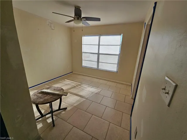 Empty room featuring light tile patterned floors, baseboards, and ceiling fan
