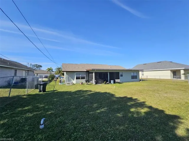 Back of house with a lawn
