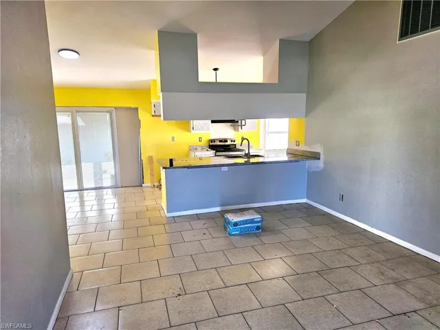 Kitchen featuring a peninsula, a healthy amount of sunlight, visible vents, and stainless steel electric range oven