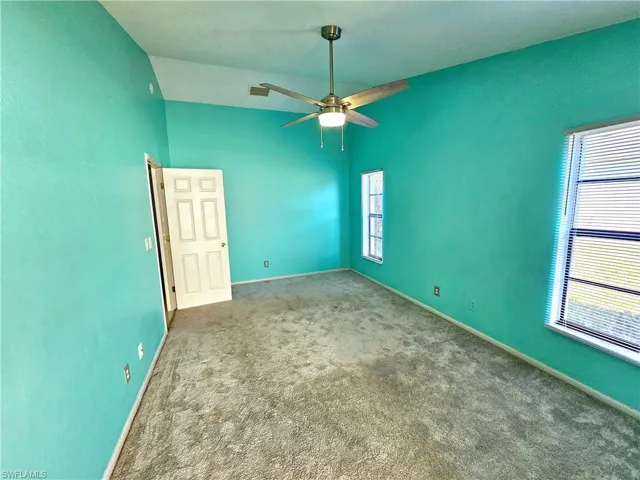 Unfurnished room featuring a wealth of natural light, baseboards, carpet floors, and ceiling fan