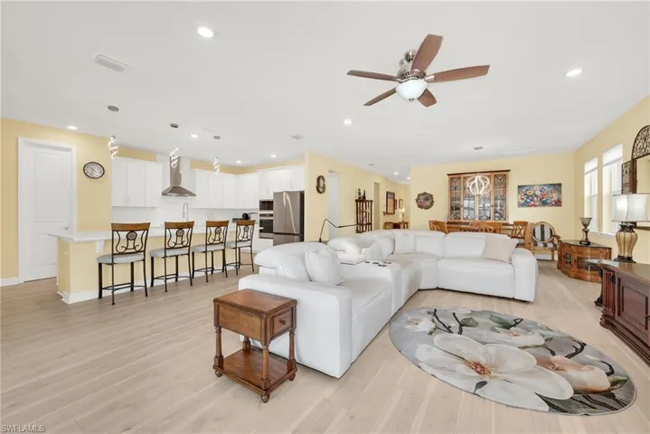 Open-concept living space featuring wood-finish flooring, recessed lighting, and a ceiling fan