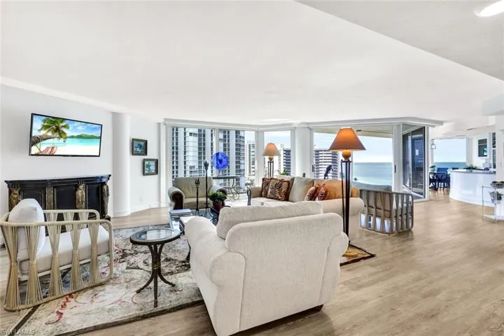 Living area with baseboards, expansive windows, and wood finished floors